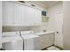 Well-organized laundry room with white cabinets, a utility sink, and washer and dryer at 1 Brookhaven Ne Dr # 301, Atlanta, GA 30319