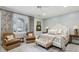 Comfortable main bedroom with a tufted headboard, neutral tones, and two chairs at 1 Brookhaven Ne Dr # 301, Atlanta, GA 30319