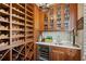 Charming wine cellar featuring custom shelving, beverage cooler, sink, and glass front cabinetry for storing glassware and spirits at 1 Brookhaven Ne Dr # 301, Atlanta, GA 30319