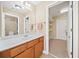 Bathroom vanity with wood cabinets, light countertops, and a doorway to a walk in closet at 3420 Aviary Ln, Acworth, GA 30101