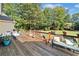 Outdoor living on wooden deck featuring comfortable seating, potted plants, and views of the landscaped yard at 3420 Aviary Ln, Acworth, GA 30101