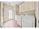 Bright laundry room with storage cabinets, sink and machines at 3420 Aviary Ln, Acworth, GA 30101