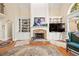 Bright living room with a stone fireplace flanked by built-in cabinets, hardwood floors, and large windows at 3420 Aviary Ln, Acworth, GA 30101