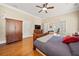 Spacious main bedroom with hardwood floors, ceiling fan, and a cozy bed with access to an attached sitting room at 3420 Aviary Ln, Acworth, GA 30101