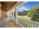 Charming porch with stone flooring, white columns and railings showcasing a view of the home across the street at 3420 Aviary Ln, Acworth, GA 30101