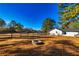 Expansive backyard with a fire pit, lush grass, mature trees, pool, and a wooden fence at 3625 Pointer Rd, Loganville, GA 30052