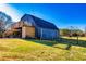 Barn with wood siding, fenced pasture, stairs, and a deck perfect for outdoor living and enjoying the surrounding scenery at 3625 Pointer Rd, Loganville, GA 30052