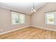 Bright bedroom with hardwood floors, two windows, and a modern light fixture at 3625 Pointer Rd, Loganville, GA 30052