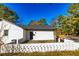 Side view of the house, featuring a patio with white brick fence, BBQ, and landscaping at 3625 Pointer Rd, Loganville, GA 30052
