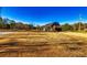 Wide view of a unique barn-style home featuring blue skies and lots of land at 3625 Pointer Rd, Loganville, GA 30052
