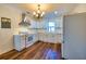 Well-lit kitchen showcasing white cabinetry, stainless steel appliances, and wood flooring at 3625 Pointer Rd, Loganville, GA 30052