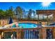 A view of the pool from the deck with a seating area and a pergola surrounded by greenery at 3625 Pointer Rd, Loganville, GA 30052