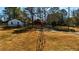 Wide shot of the home and landscape, featuring windmill, small red barn and fenced yard at 3625 Pointer Rd, Loganville, GA 30052