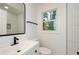 Modern bathroom featuring black hardware, white vanity and tile, and window at 474 Fairlock Nw Ln, Atlanta, GA 30331