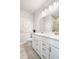 Bright bathroom showcasing double sinks, white cabinetry, modern fixtures, and decorative wall art at 443 Village Ln, Fairburn, GA 30213