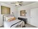 Comfortable bedroom featuring two pieces of modern artwork, ceiling fan, and small black dresser at 443 Village Ln, Fairburn, GA 30213