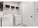 Functional laundry room with shelving for storage and modern appliances at 443 Village Ln, Fairburn, GA 30213