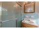 Bathroom view showcasing shower with patterned glass, vintage blue tile, and a wood vanity with a white sink at 4485 Canary Ct, Lithia Springs, GA 30122