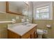 Bathroom features a wooden framed mirror, and a window that provides natural light at 4485 Canary Ct, Lithia Springs, GA 30122