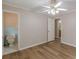 Bedroom features laminate wood flooring, a ceiling fan with lights, and an open door to a bathroom at 4485 Canary Ct, Lithia Springs, GA 30122