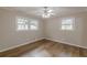 Bedroom featuring laminate flooring, neutral paint, two windows, and a ceiling fan at 4485 Canary Ct, Lithia Springs, GA 30122