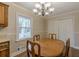 Cozy dining room features a classic chandelier, wood table, and bright natural light from the window at 4485 Canary Ct, Lithia Springs, GA 30122