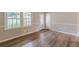 View of the front room of the home, which has new wood-look floors, molding, and a window at 4485 Canary Ct, Lithia Springs, GA 30122