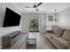 Bright living room with modern ceiling fan, decor light fixture, and sliding glass door to balcony at 1081 Liberty Pkwy, Atlanta, GA 30318