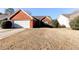 Brick ranch home with attached garage and grassy yard at 1624 Graystone Dr, Hampton, GA 30228