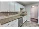 White cabinets, granite counters, and tile backsplash in kitchen at 1624 Graystone Dr, Hampton, GA 30228