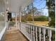 View of a front porch with white wooden railings overlooking the home's large front yard and a wooded area at 2138 Rockdale Cir, Snellville, GA 30078