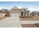 Brick home with 2-car garage, landscaping, and a front porch at 615 Grassmeade Ln, Woodstock, GA 30188