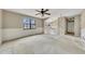 Empty living room featuring a ceiling fan, large window, and stairway at 336 Adelene Way, Dallas, GA 30157