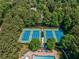 Aerial view featuring tennis courts within a lush, green, tree-lined community at 1506 Brookridge Dr, Woodstock, GA 30189