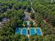 Stunning aerial view showcasing tennis courts, swimming pool, clubhouse, and lush surrounding trees at 1506 Brookridge Dr, Woodstock, GA 30189