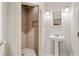 Bathroom featuring tiled shower, pedestal sink, and modern lighting at 1506 Brookridge Dr, Woodstock, GA 30189
