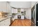 Modern kitchen with stainless steel appliances, granite countertops, white cabinets and hardwood floors, combining style and functionality at 1506 Brookridge Dr, Woodstock, GA 30189