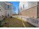 Charming backyard featuring a white picket fence, lush grass, and well-manicured landscaping at 646 Brashy St, Woodstock, GA 30188