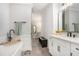 Spa-like bathroom with a soaking tub, white vanity, and modern black hardware at 646 Brashy St, Woodstock, GA 30188