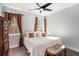 Cozy bedroom with a large window, dark ceiling fan, and comfortable white bedding at 646 Brashy St, Woodstock, GA 30188