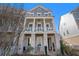 Three-story townhome, gray siding, white columns, front porch at 646 Brashy St, Woodstock, GA 30188