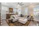 Bright living room featuring an L-shaped sofa with an ottoman, hardwood floors, and a large area rug at 646 Brashy St, Woodstock, GA 30188