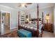 Main bedroom with four poster bed, sitting area and hardwood floors at 646 Brashy St, Woodstock, GA 30188