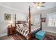 Bright main bedroom featuring a four-poster bed, decorative ceiling fan, and hardwood floors at 646 Brashy St, Woodstock, GA 30188