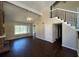 Spacious living room featuring vaulted ceilings, modern fan, wood floors, and stairs at 1153 Village Main St, Stone Mountain, GA 30088