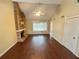 Bright living room with a brick fireplace, modern ceiling fan, and wood flooring at 1153 Village Main St, Stone Mountain, GA 30088