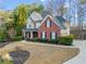 Inviting two-story home with a well-manicured lawn, mature trees, and a side-entry garage at 2007 Woodside Park Dr, Woodstock, GA 30188