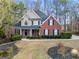 Charming two-story home features a manicured front lawn, complemented by mature trees and landscaping at 2007 Woodside Park Dr, Woodstock, GA 30188