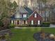 Charming two-story home features a manicured front lawn, complemented by mature trees and landscaping at 2007 Woodside Park Dr, Woodstock, GA 30188