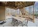 Covered patio with outdoor dining area under an elevated wooden deck with stairs at 2007 Woodside Park Dr, Woodstock, GA 30188